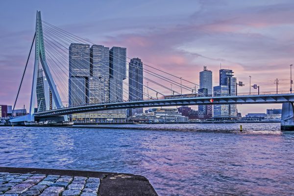 Rotterdam, The Netherlands, February 13, 2019: a striking purple sunset sky over the Nieuwe Maas river with Erasmus bridge and Wilhelminapier jighrise in the background